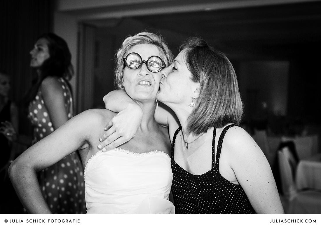 Braut wird von Gast bei Hochzeitsfeier im Stapelskotten Münster auf die Wange geküsst