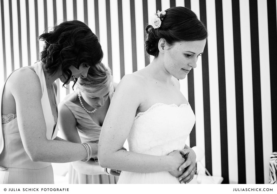 Trauzeuginnen helfen Braut beim Ankleiden