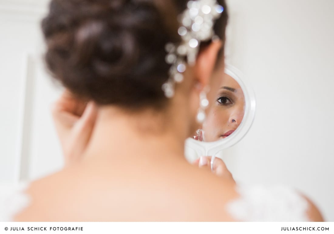 Braut schaut in den Spiegel standesamtlicher Trauung auf Sportschloss Velen im weißen Saal der Orangerie