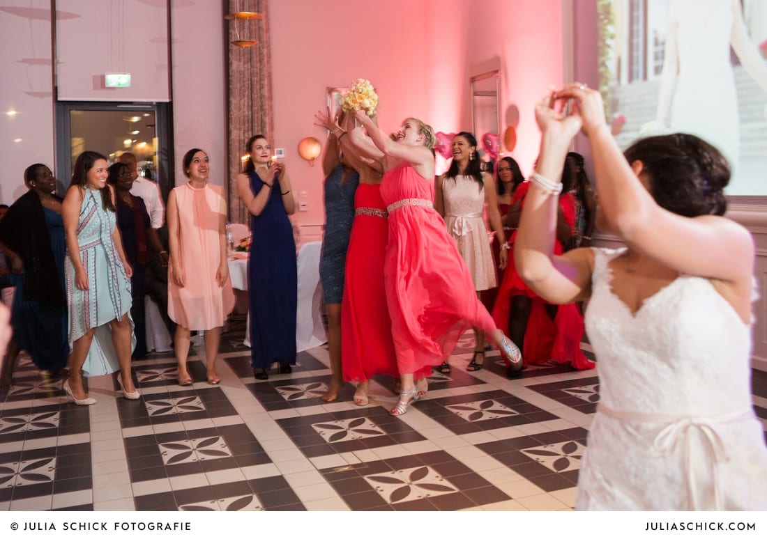 Trauzeugin fängt Brautstrauß bei Hochzeitsfeier in der Remise des SportSchloss Velen