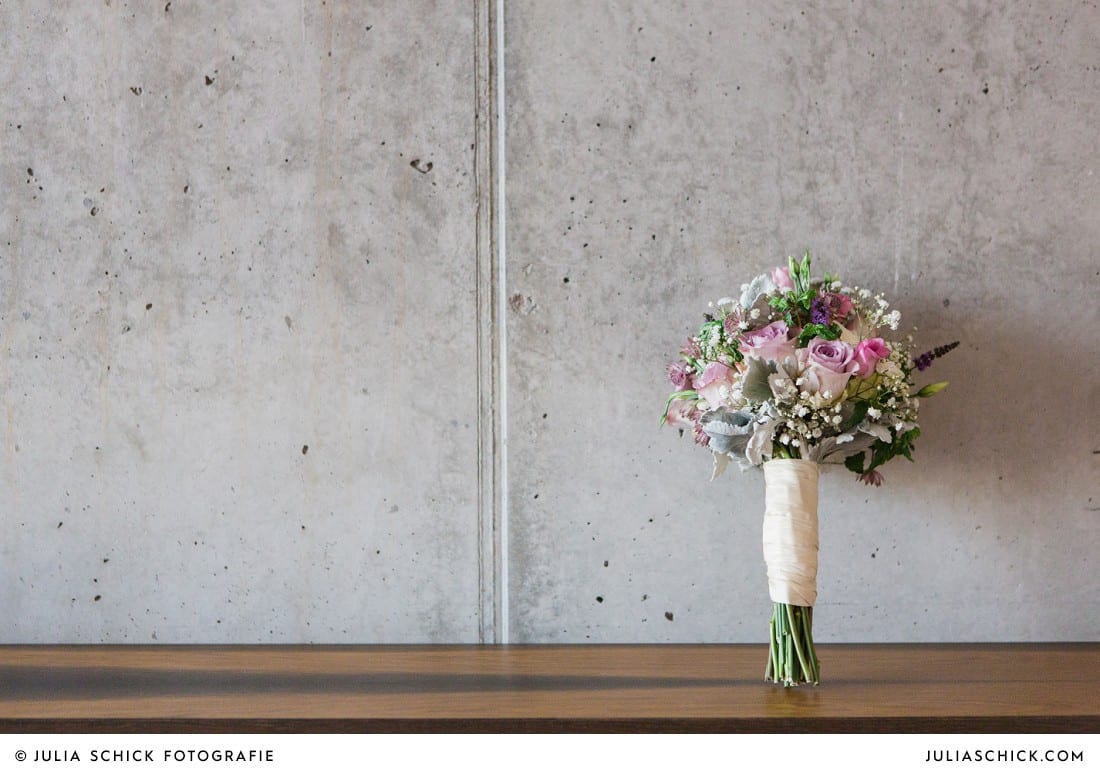 Brautstrauß von die Floristen in Münster vor Betonwand im Factory Hotel