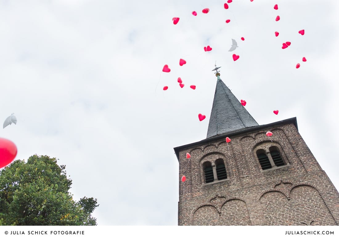 Luftballons vor Kirchturm der Sankt Antonius Kirche in Leverkusen Wiesdorf