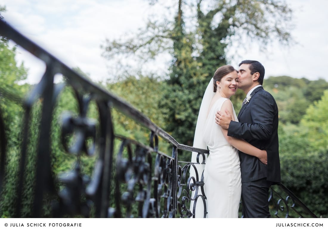 Bräutigam küsst Braut auf Schläfe auf Schloss Eicherhof in Leichlingen