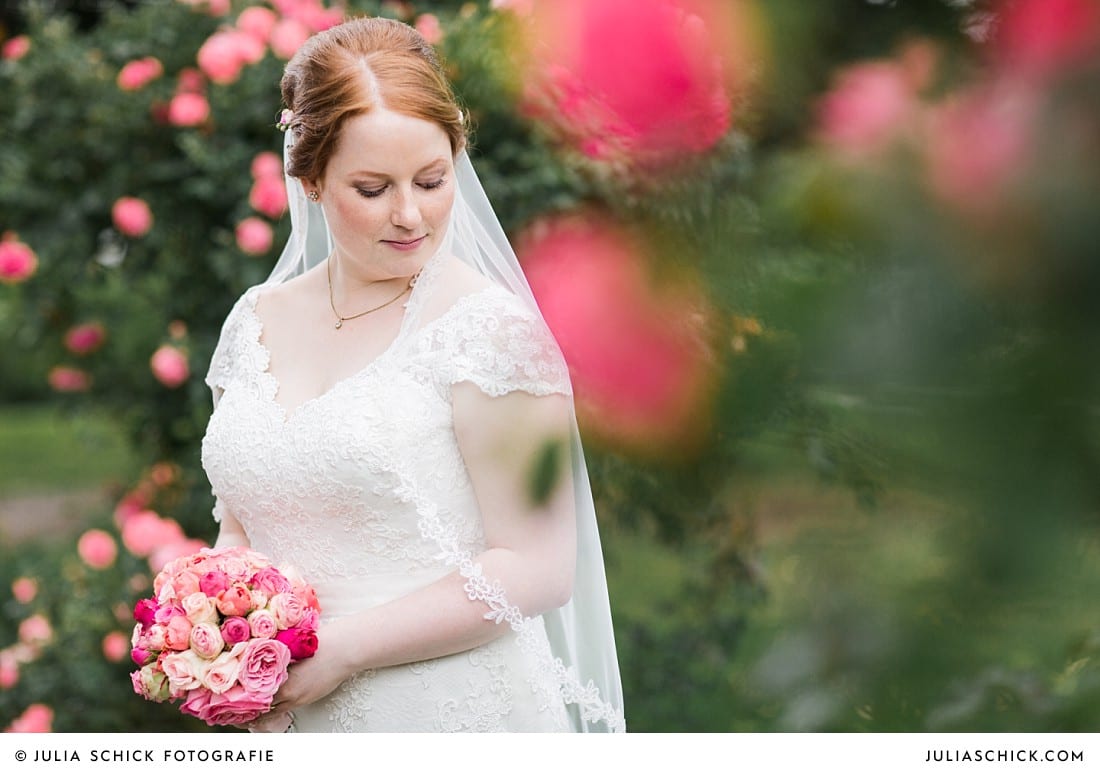 Braut umgeben von Rosen bei Hochzeitsfotoshooting im Rosengarten Seppenrade
