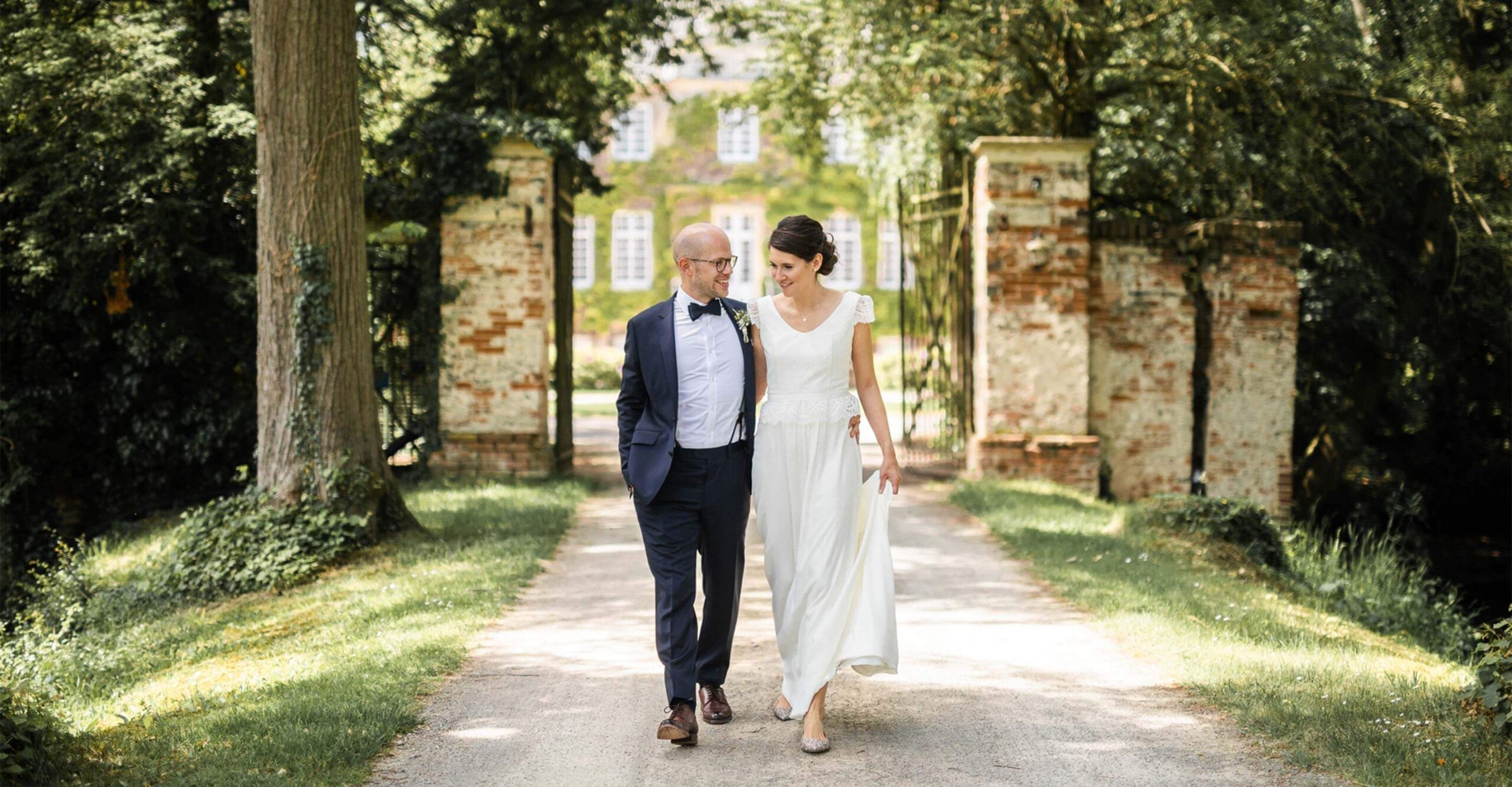 Hochzeitspaar beim Hochzeitsfotoshooting auf der Allee vor Haus Ruhr, einer Hochzeitslocation in Senden bei Münster.