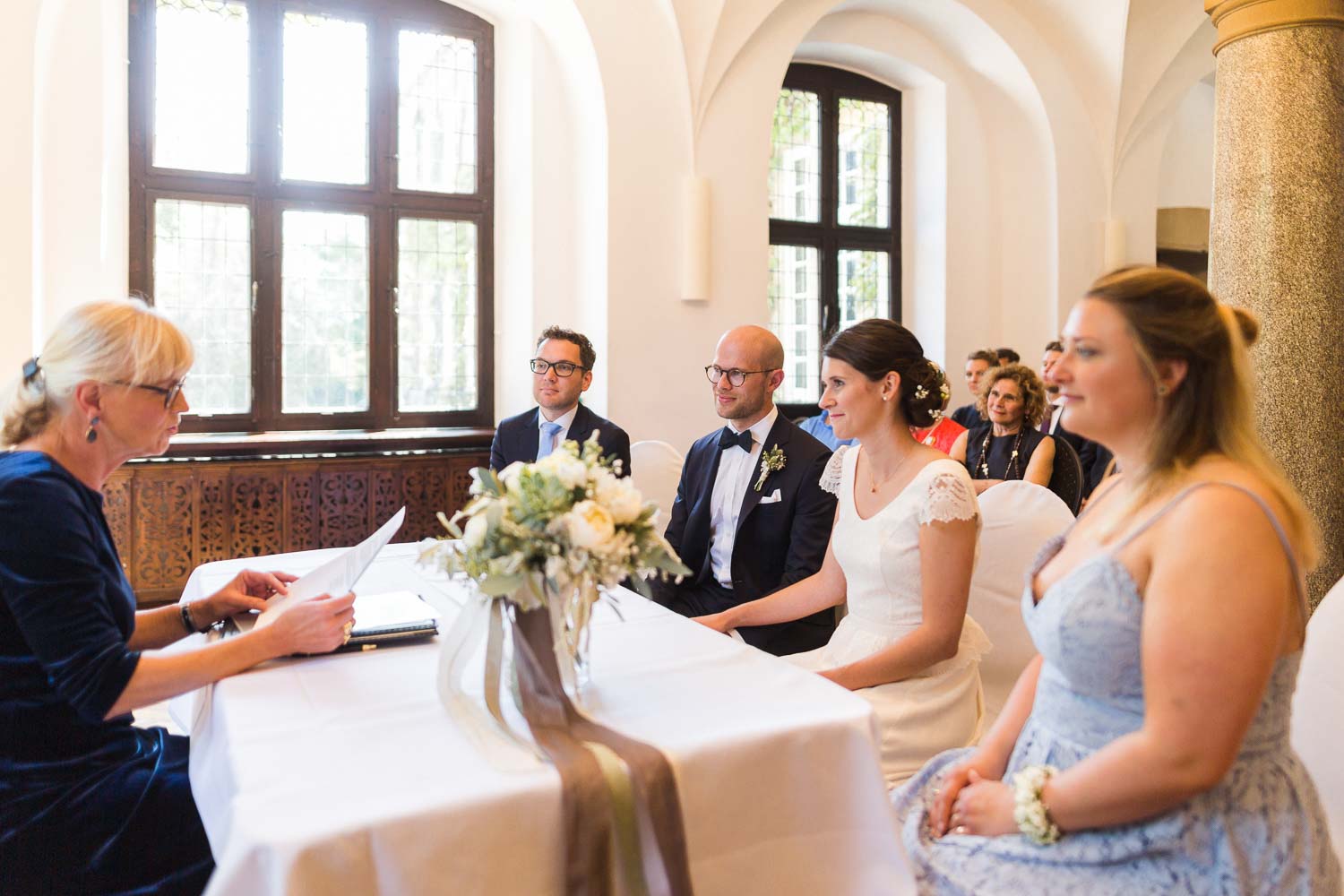 Brautpaar sitzt vor der Standesbeamtin Oda von und zur Mühlen im Rittersaal von Haus Ruhr sin Senden