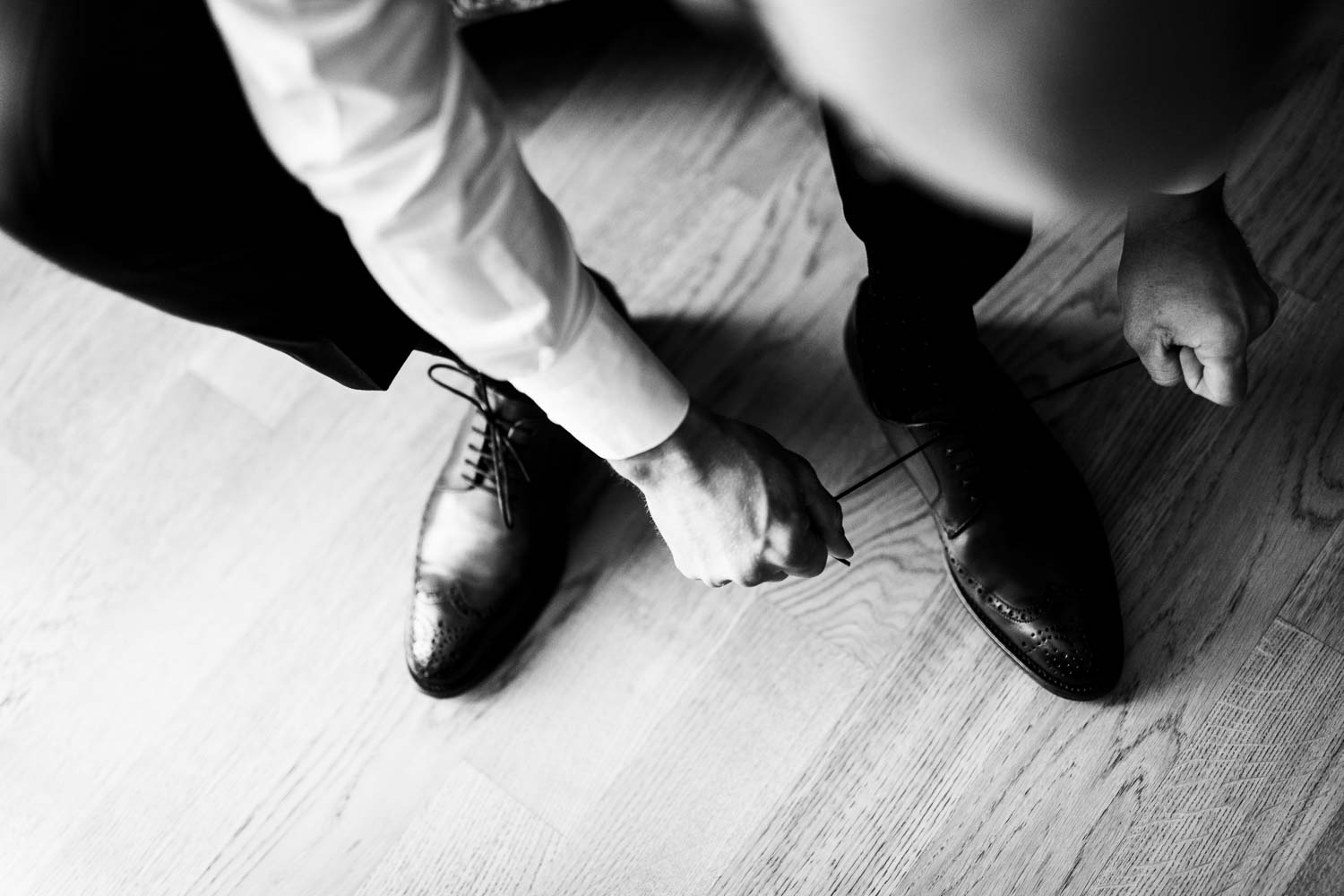Bräutigam zieht sich die Schuhe beim Getting Ready in einem Zimmer des Hofhotels Grothues-Potthoff an