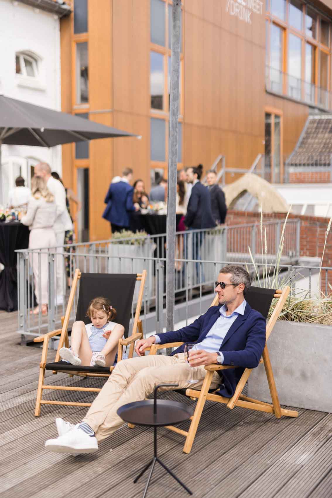 Zwei Hochzeitsgäste sitzenb in Strandklappstühlen auf der Terraasse der Seaside, einem Vernanstaltungsraum des Factory Hotel Münster