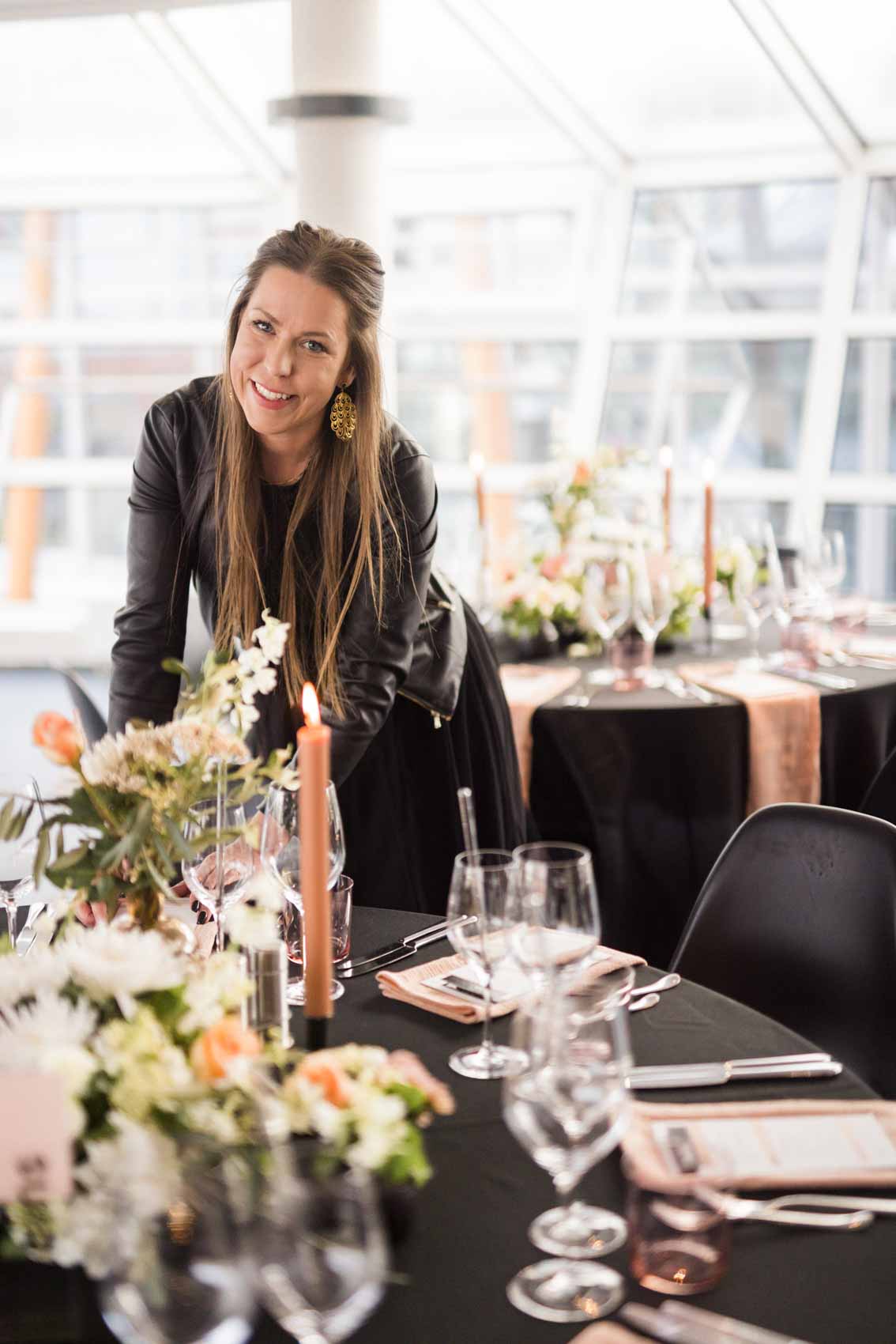 Hochzeitsplanerin Steffi Große Ostendorf dekoriert einen Hochzeitstisch mit schwarzer Tischdecke, Blumen und Kerzen in peach und weiß im Factory Hotel 