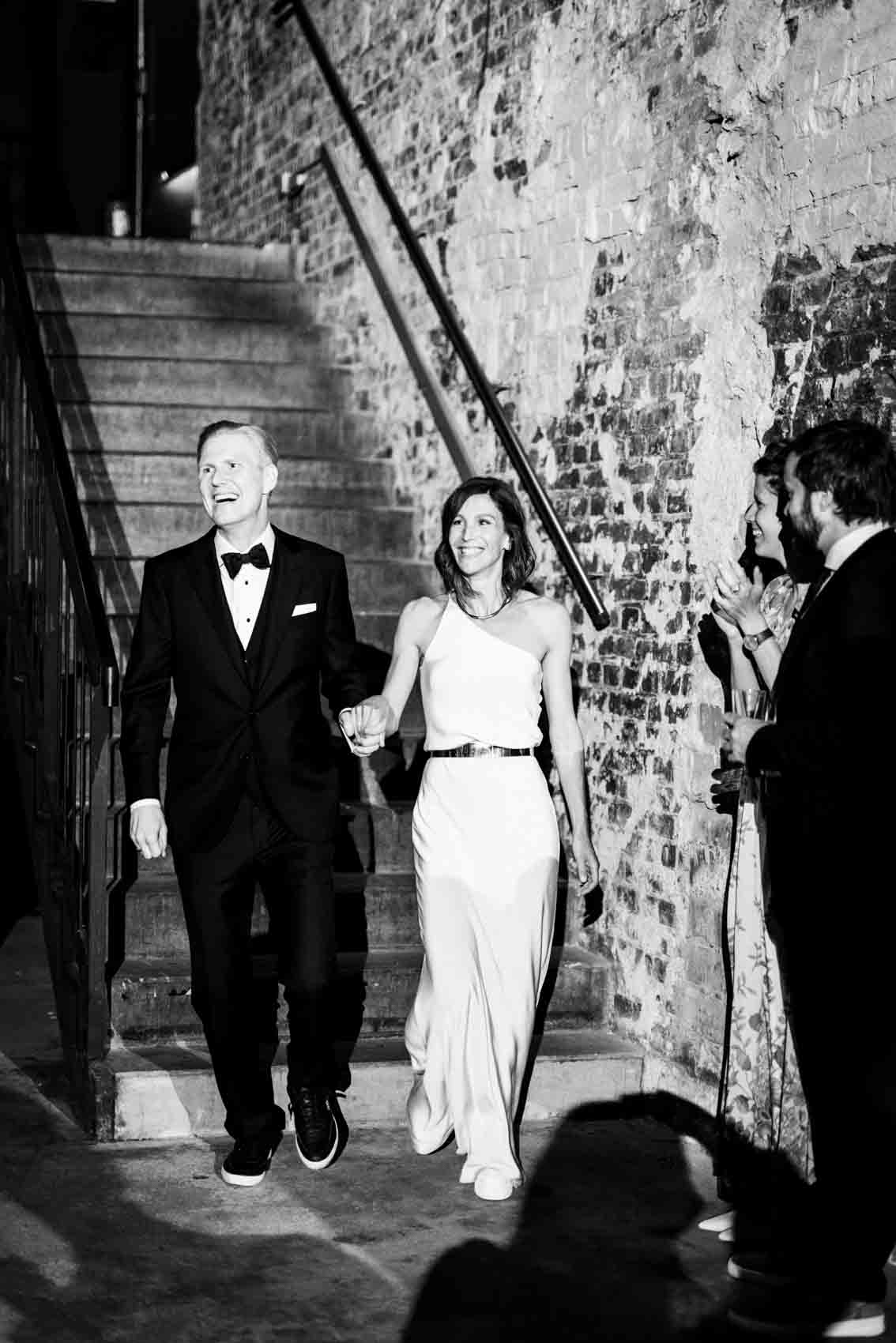 Brautpaar schreitet jubelnd die Treppe hinunter zum Club Grey im Keller des Factory Hotel Münster
