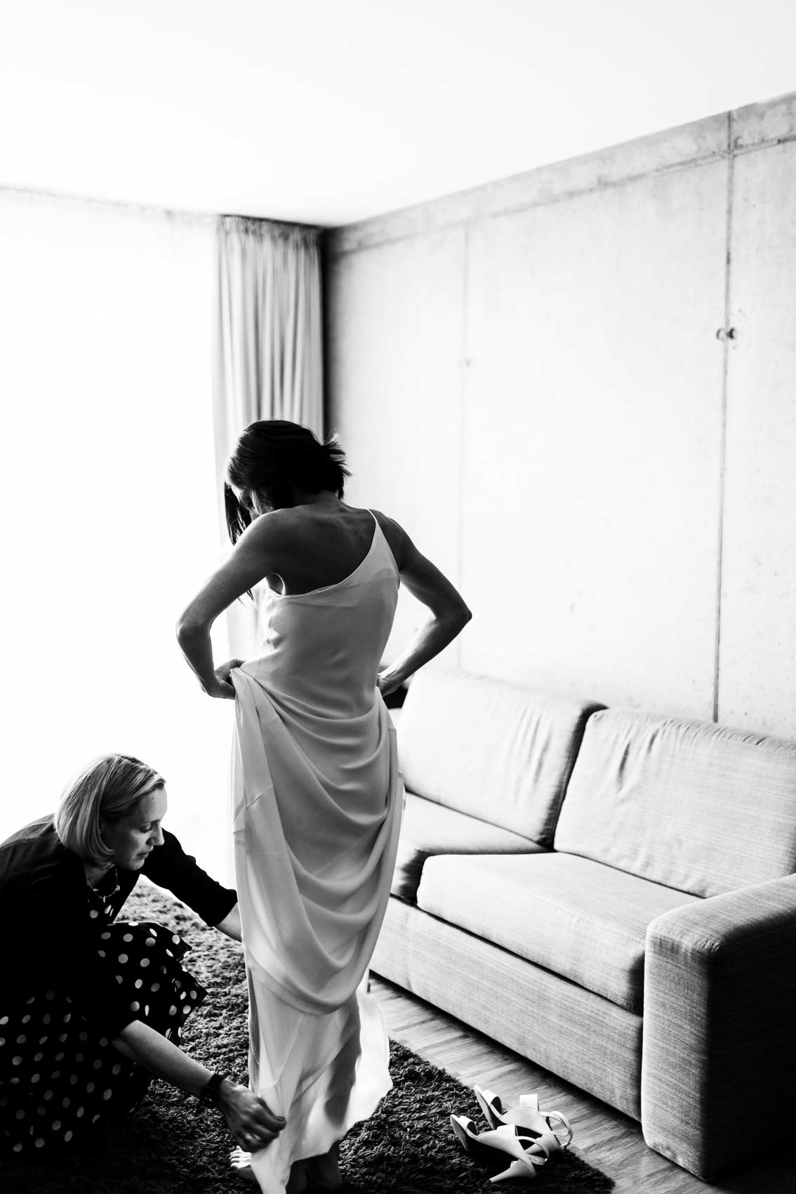 Braut beim Anziehen des Brautkleids beim Getting Ready in einer Suite des Factory Hotels Münster