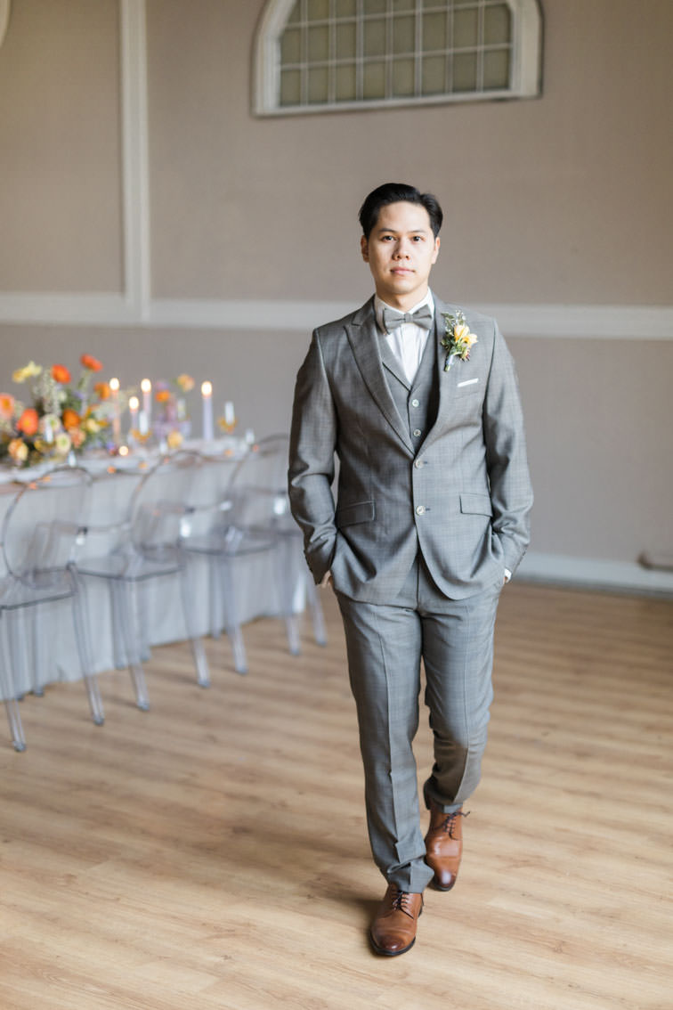 Asiatischer Bräutigam in grauem Anzug von Wilvorst im großen Saal der Hochzeitslocation Kneisterei in Münster