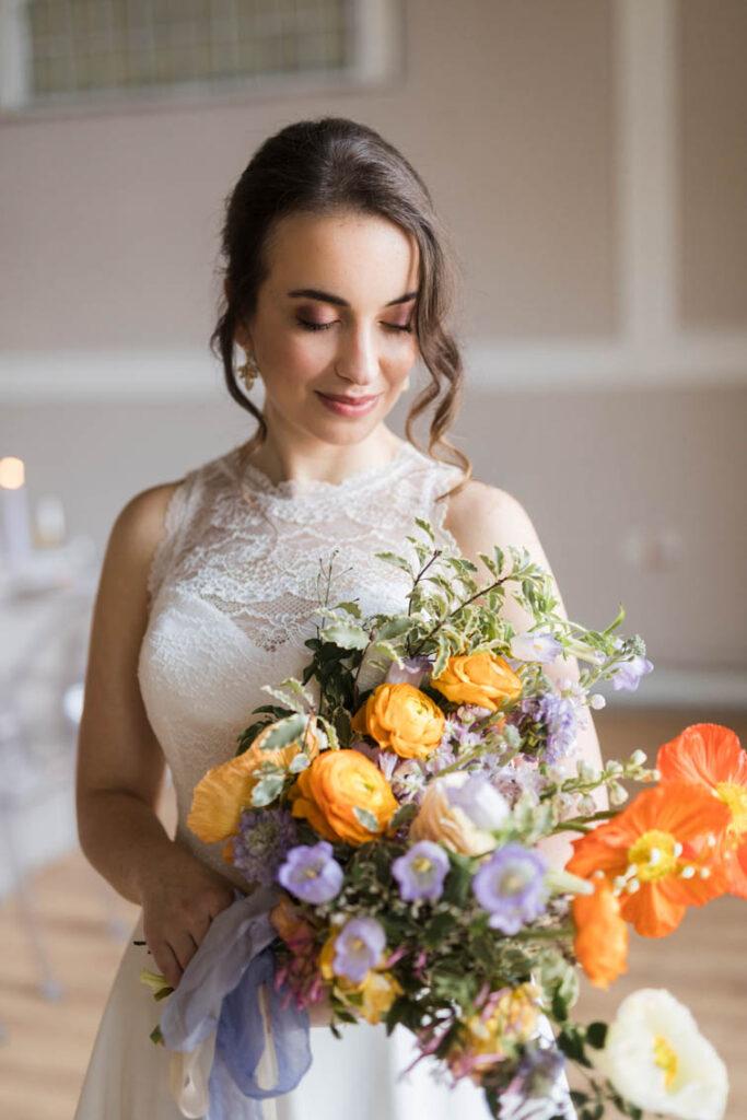 Braut mit großem Brautstrauß in lila, gelb und orange von Federherz Deko