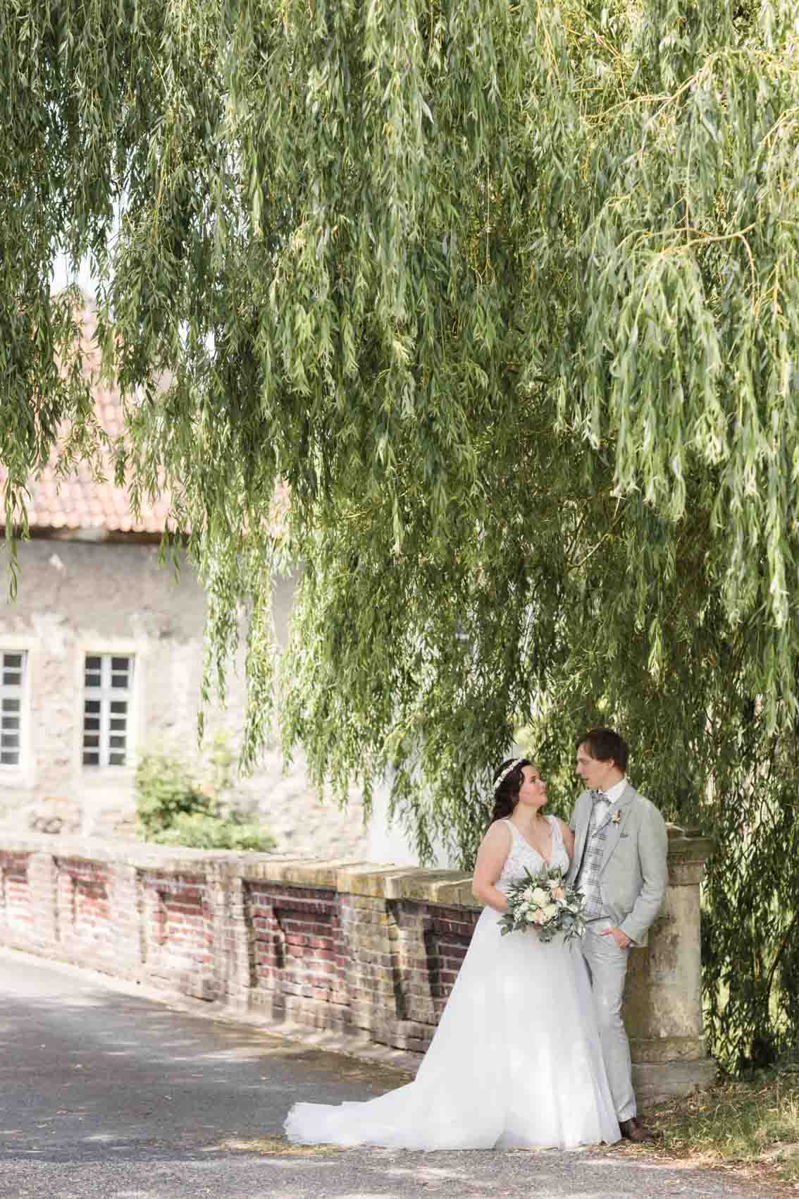 Brautpaar bei Hochzeitsfotoshooting auf Brücke hinter Schloss Buldern in Dülmen