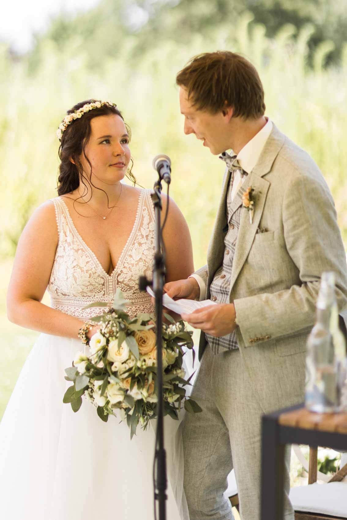 Hochzeitspaar gibt sich ein Eheversprechen bei einer freien Trauung im Garten der Hochzeitslocation Seescheune am Bulderner See in Dülmen