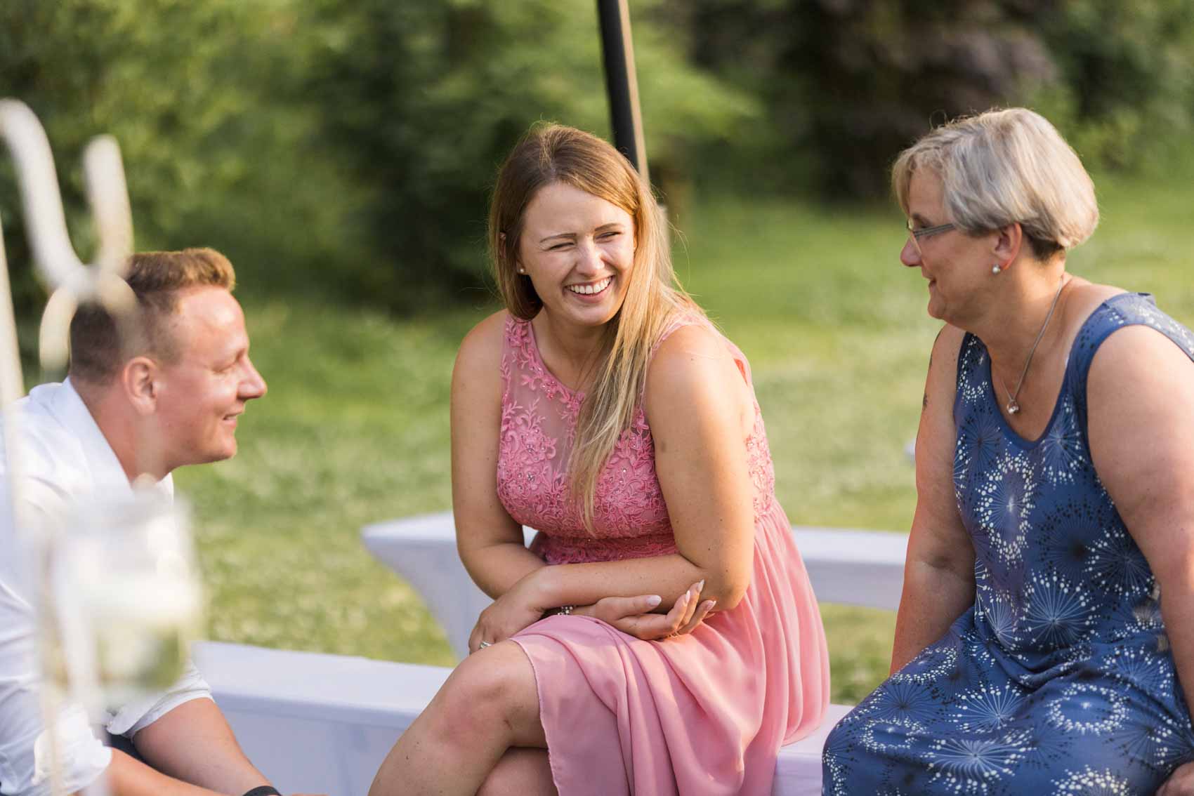 Drei lachende Gäste bei einer Hochzeitsfeier in der Hochzeitslocation Seescheune am Bulderner See in Dülmen