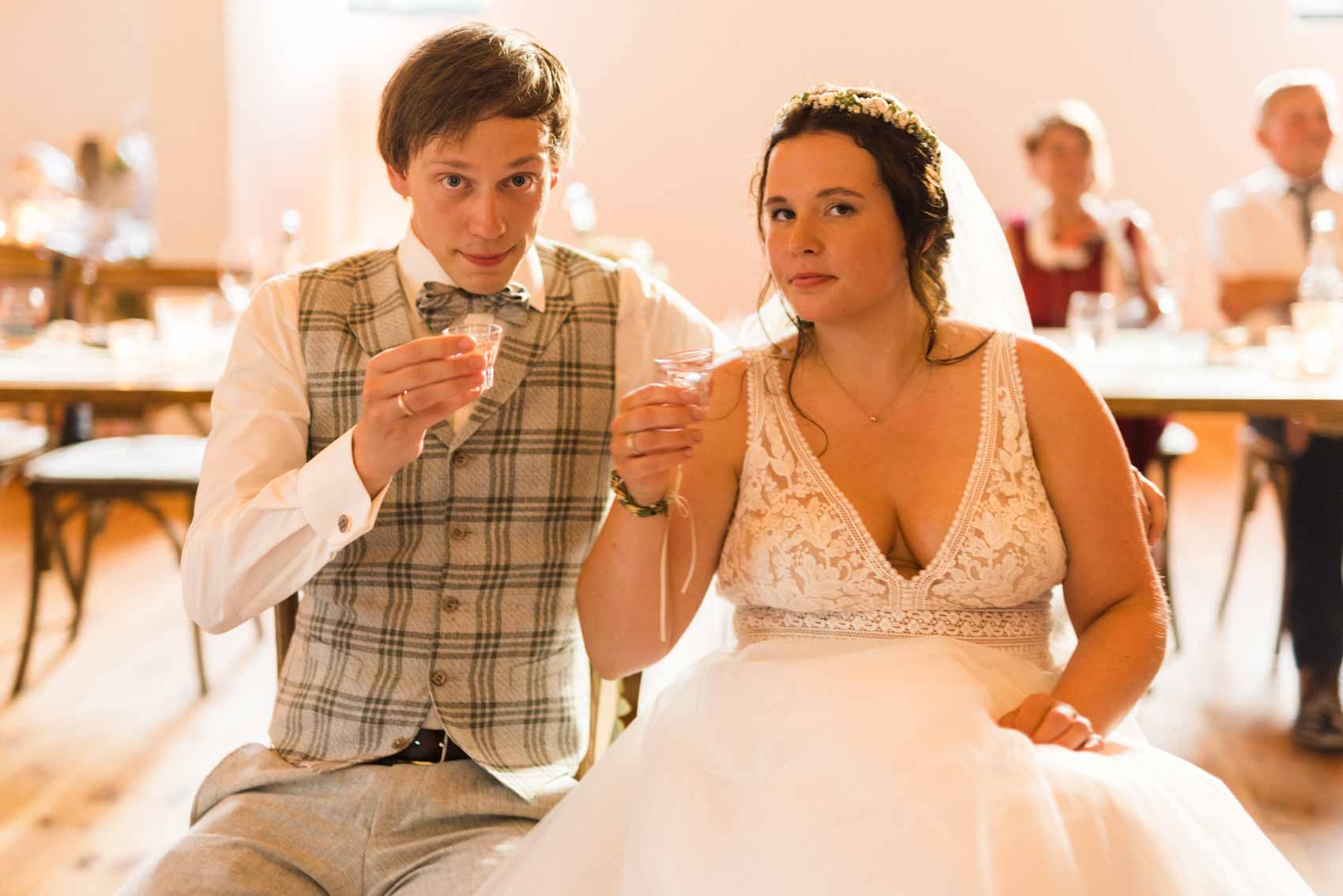Brautpaar trinkt Schnaps aus einem Pinchen bei einer Hochzeitsfeier in der Hochzeitslocation Seescheune am Bulderner See in Dülmen