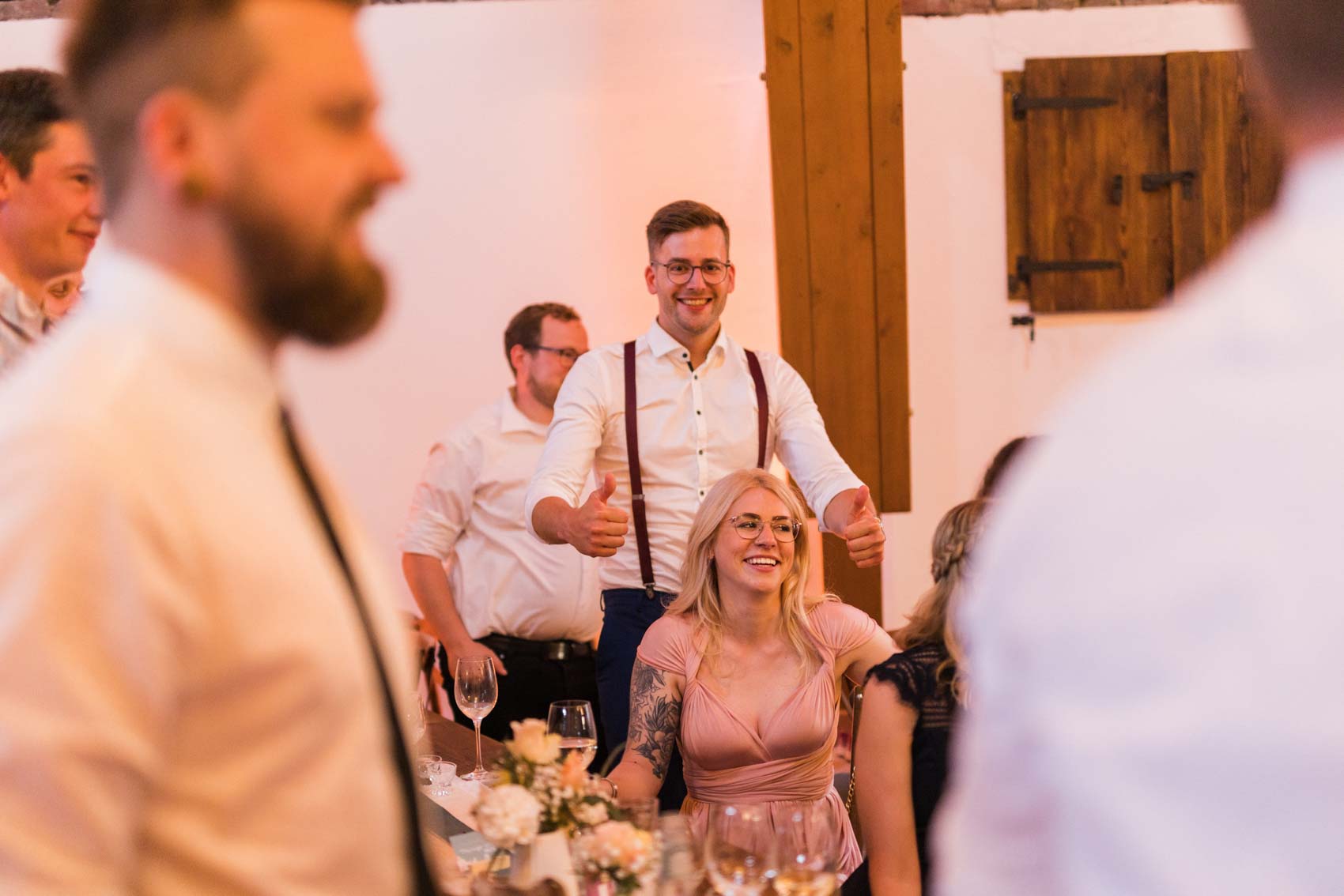 Gäste lachen bei einem Hochzeitspiel bei einer Hochzeitsfeier in der Hochzeitslocation Seescheune am Bulderner See in Dülmen