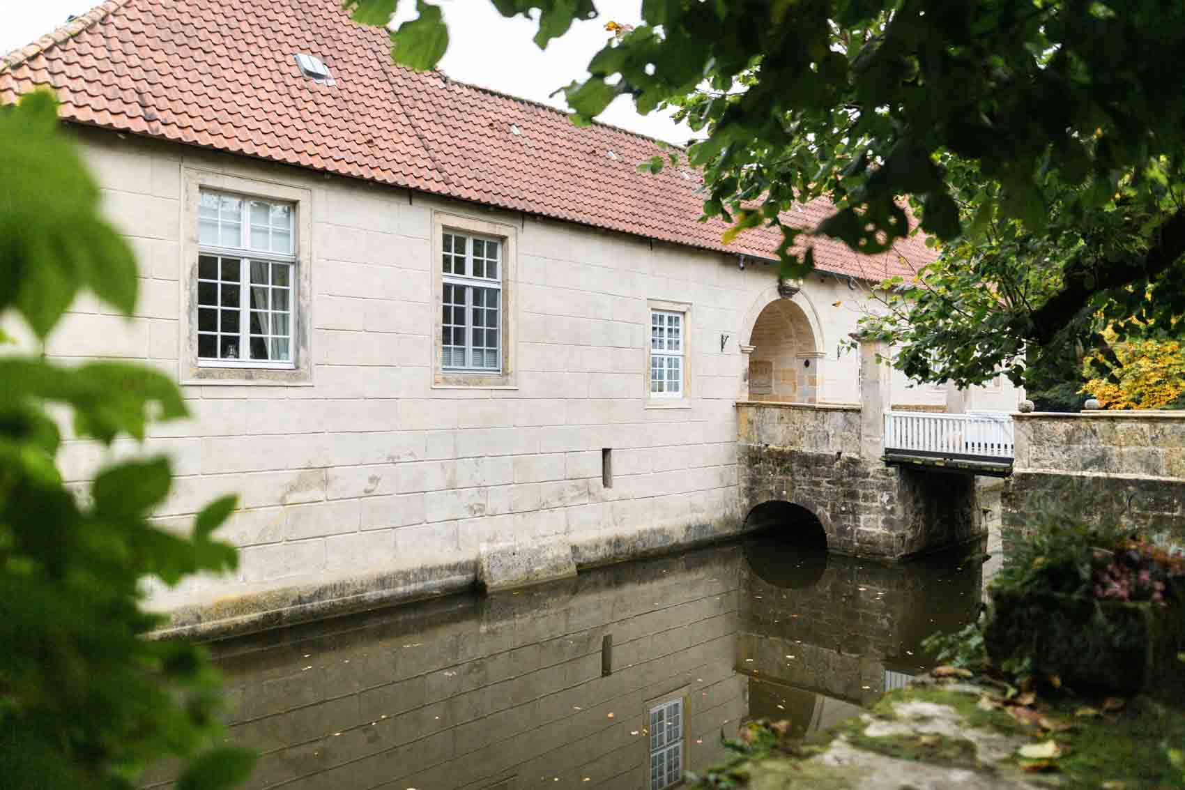 Eingangsbereich des Wasserschlosses Haus Marck in Tecklenburg mit Brücke und Wassergraben.