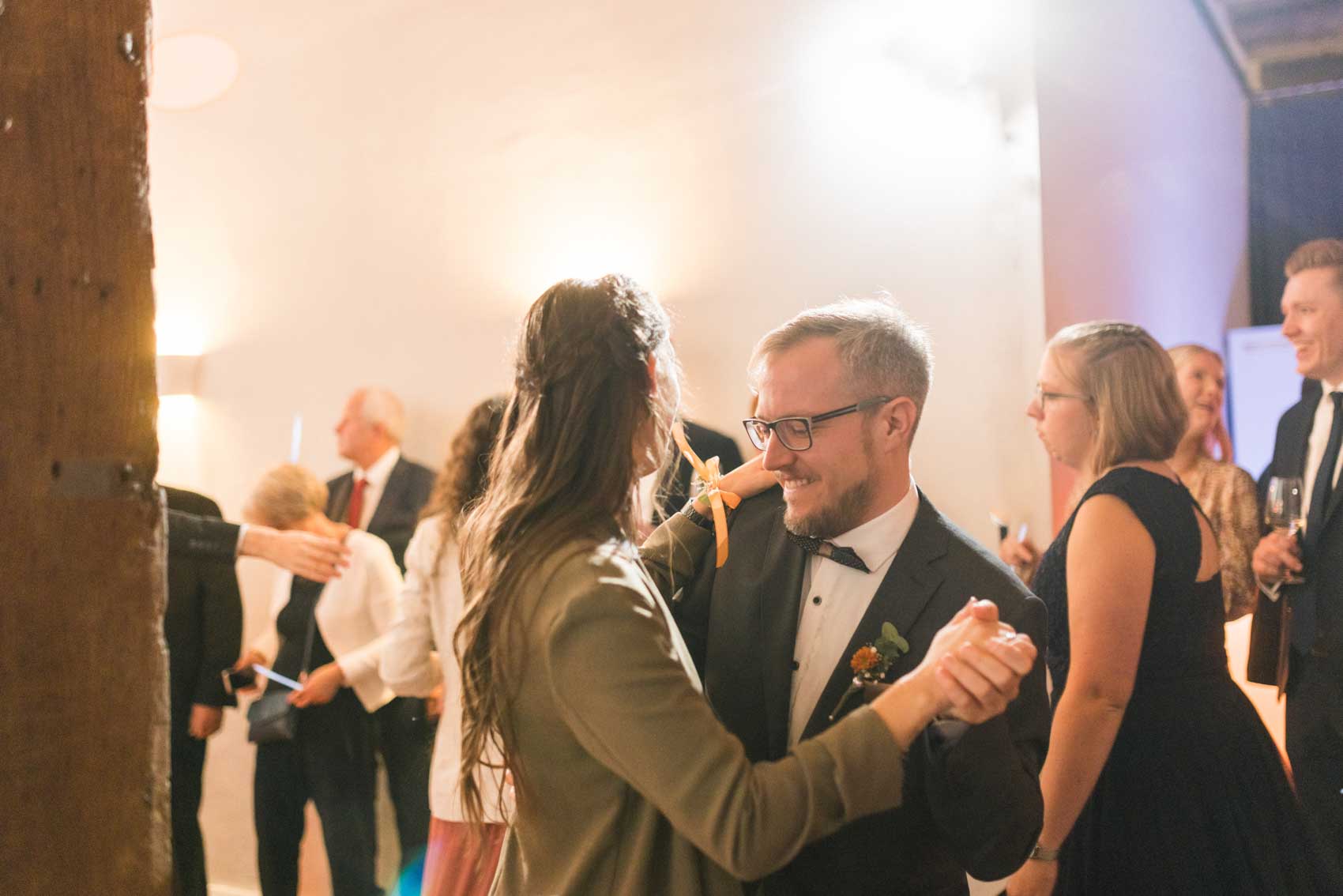 Tanzendes Gästepaar beim Hochzeitstanz im Saal der Hochzeitslocation Haus Runde in Billerbeck. 